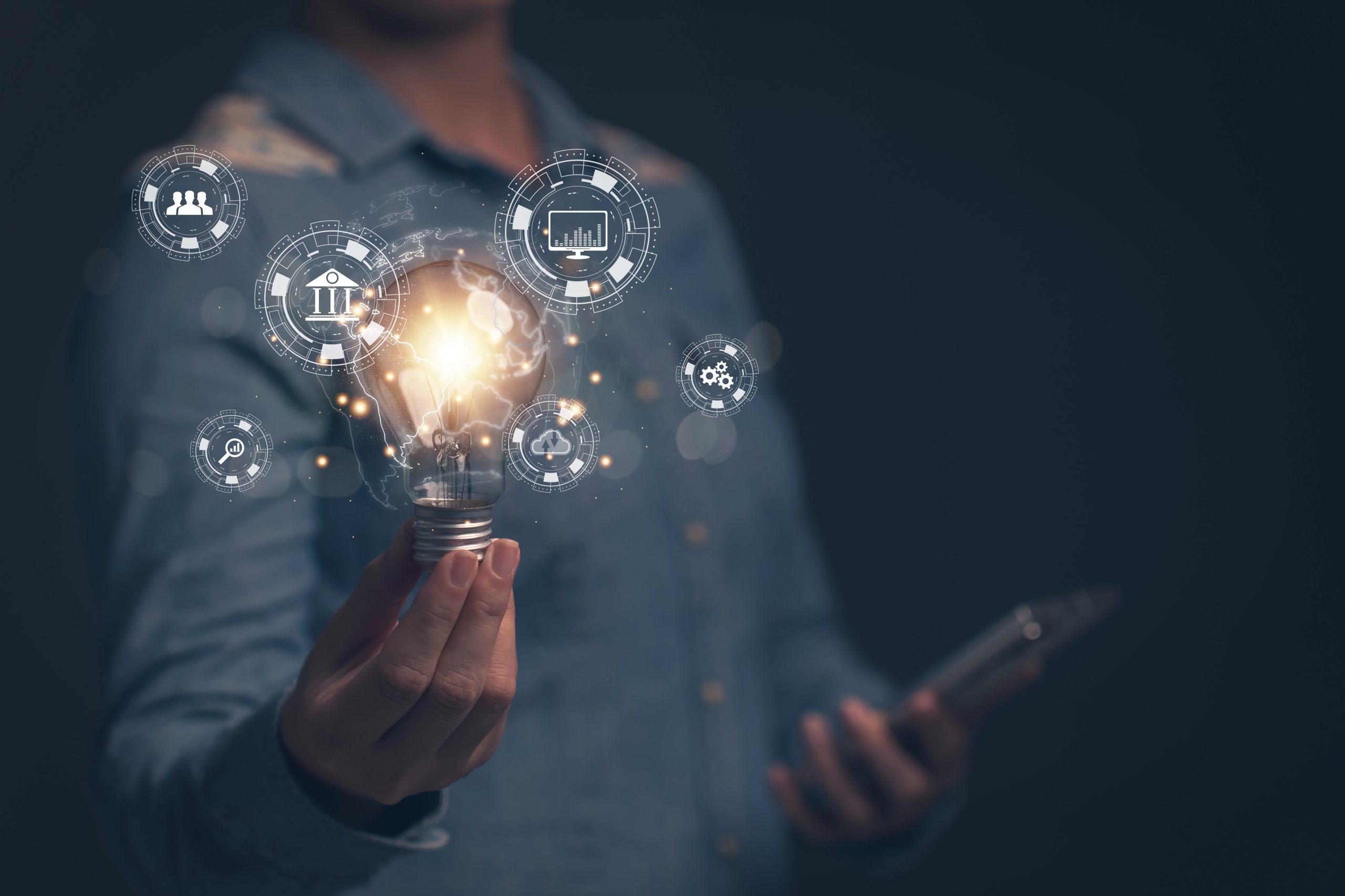 Person holding a lit lightbulb